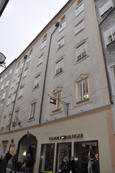 Graues modernes Gebäude mit fünf Stockwerken und einem Geschäft im Erdgeschoss.